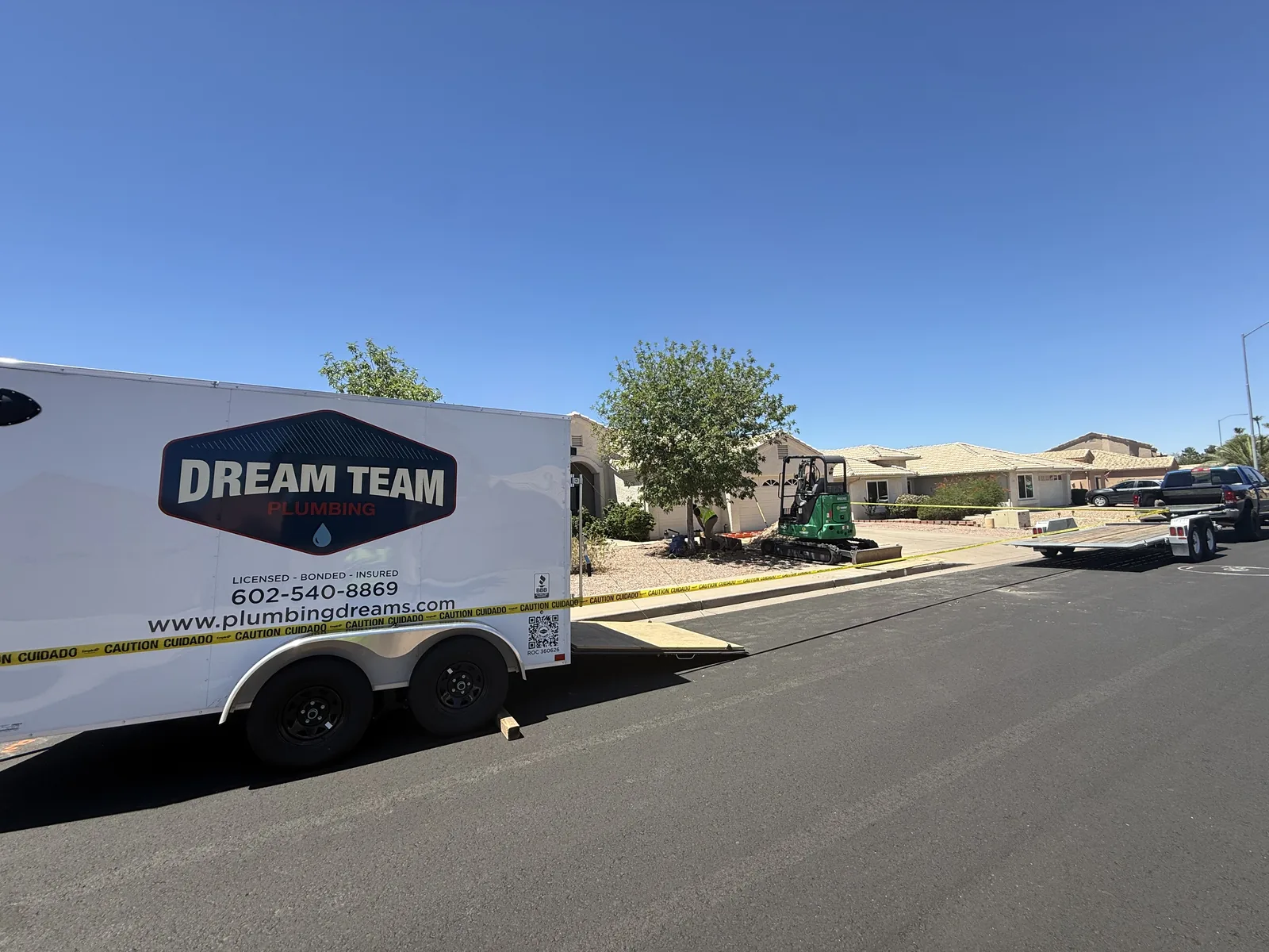 Actual Dream Team Plumbing trailer and compact excavation equipment staged at a Mesa-area residential project